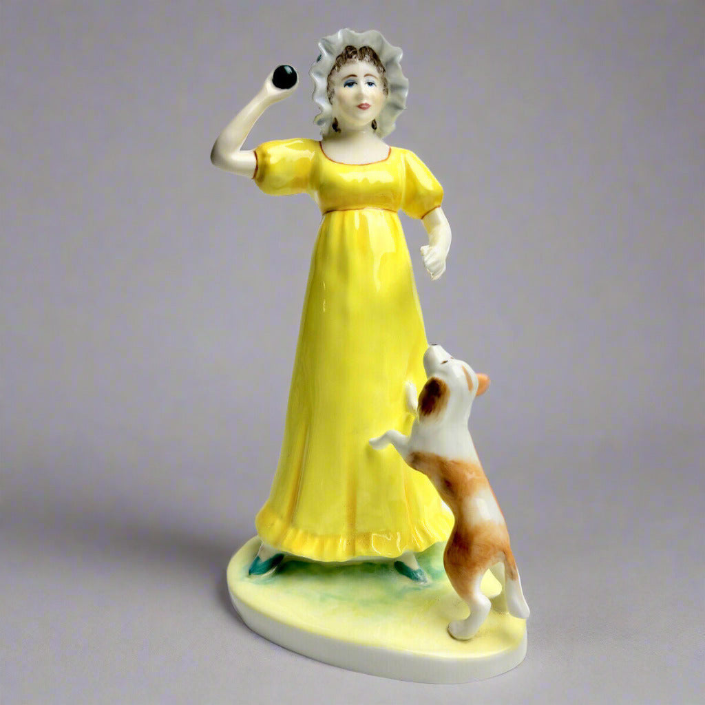 Porcelain figurine of a woman in a yellow dress with a dog on a white background
