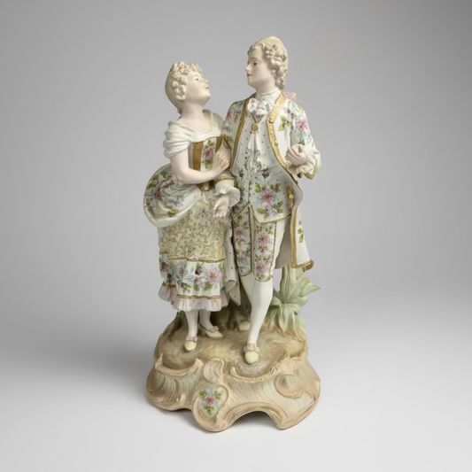 Decorative figurine of two people in formal attire on a gray background