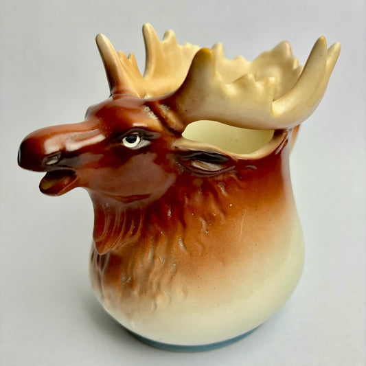 A ceramic pitcher in the shape of a moose with a brown and beige color scheme.