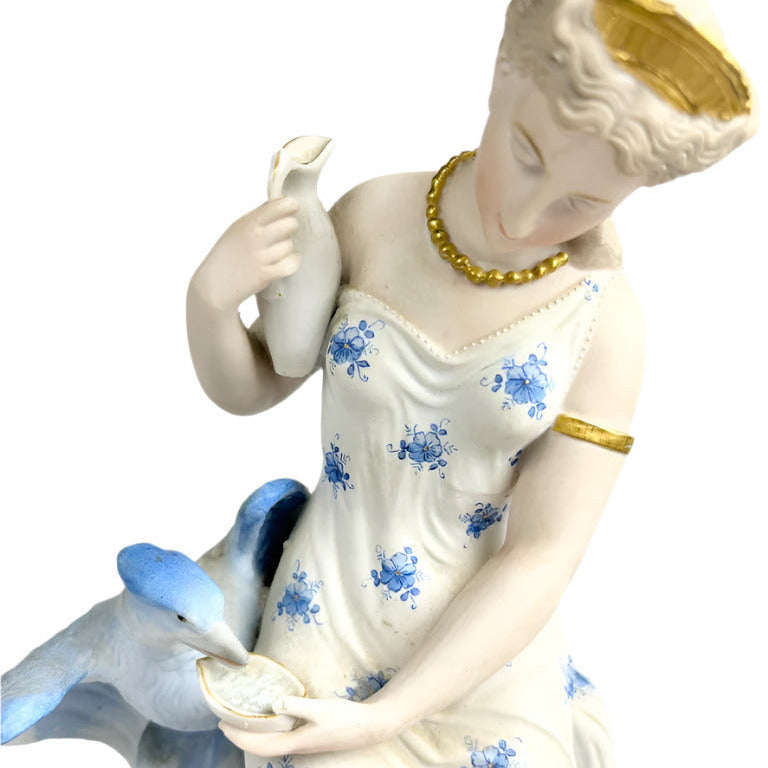 Porcelain figurine of a woman holding a bird with floral patterns on a white background