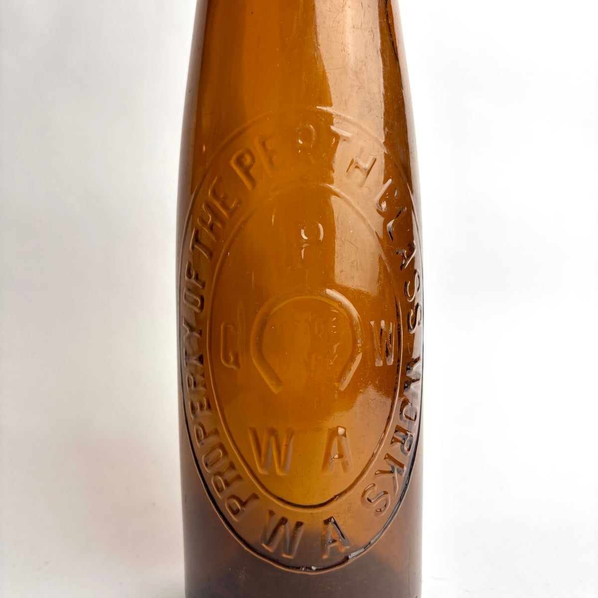 Close-up of a brown bottle with a logo on a white background