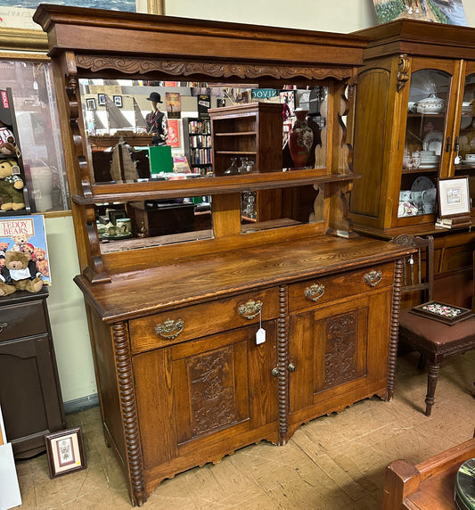 Wooden cabinet with open doors displaying various items on a carpeted floor.