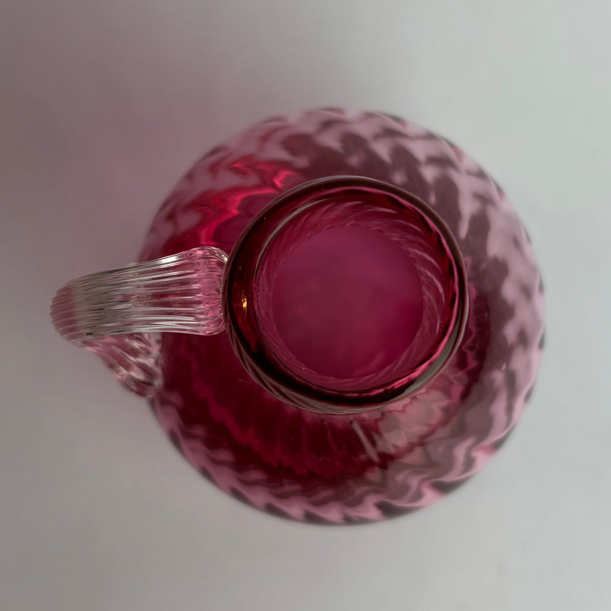 Pink glass pitcher on a white background