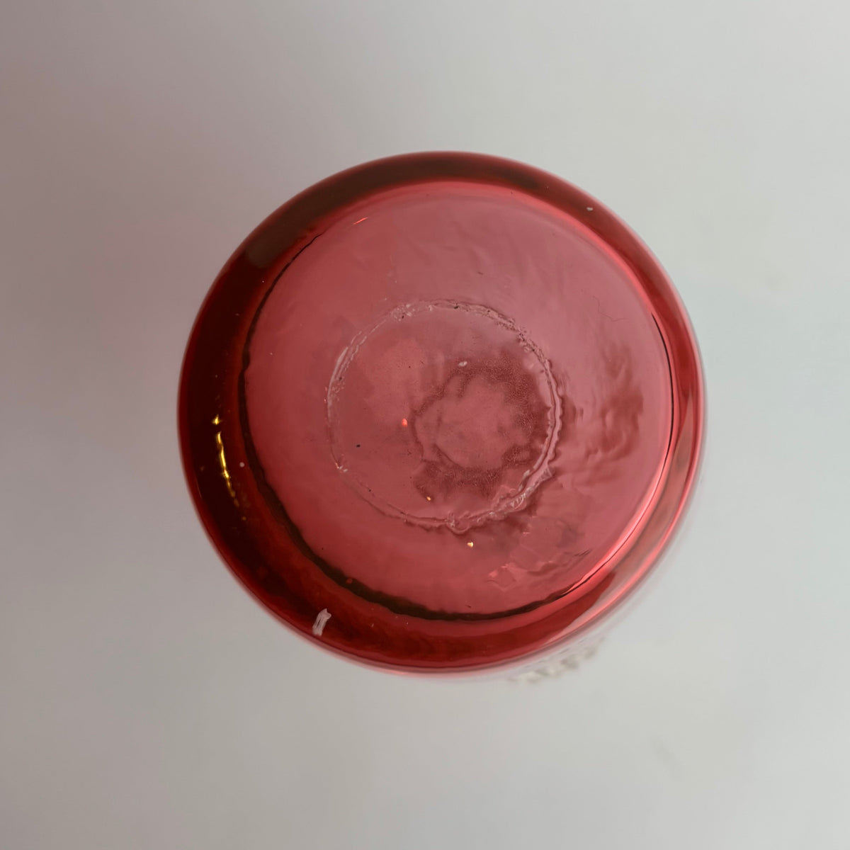 Close-up of a red metallic object on a light gray background