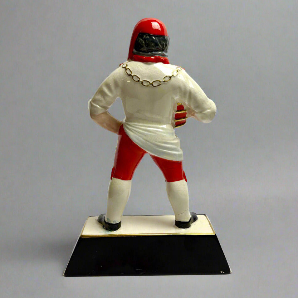 Figurine of a brewer in red and white uniform on a gray background