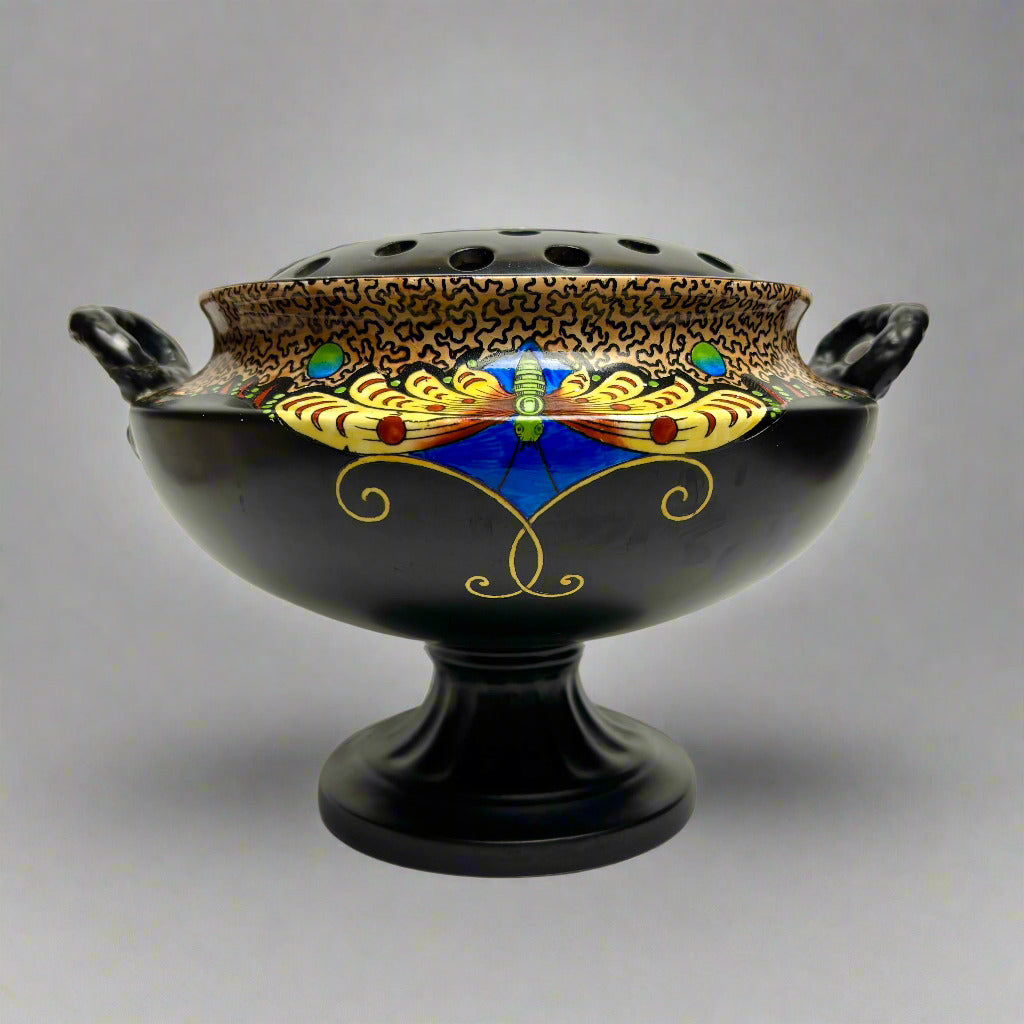 Decorative black bowl with gold, blue, and red patterns on a gray background