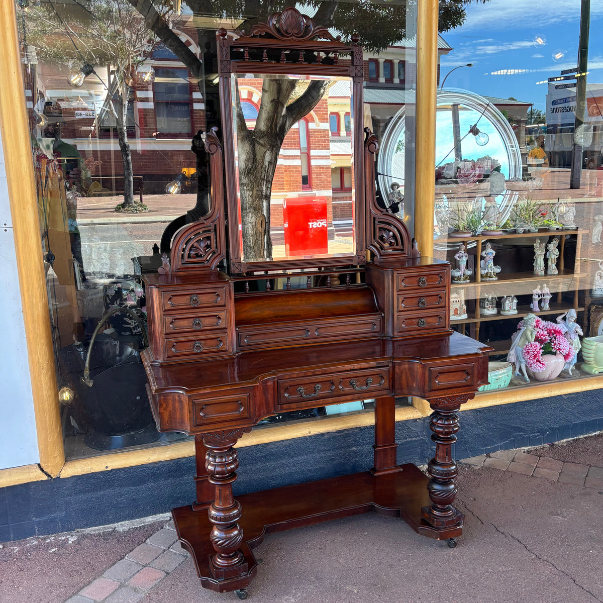 Vintage wooden vanity with mirror in front of a store window