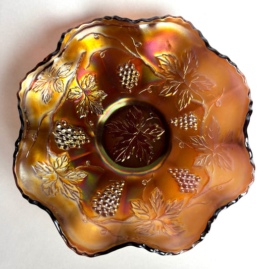 Decorative glass dish with leaf and grapevine patterns on a white background