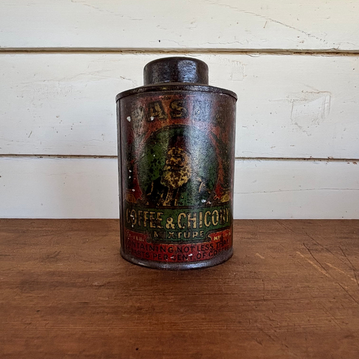 Vintage tin can with coffee and chocolate advertisement on a wooden surface