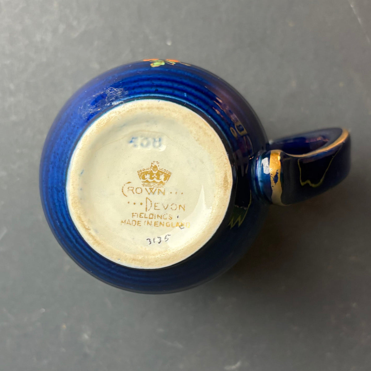 Blue ceramic mug with visible branding on a dark surface
