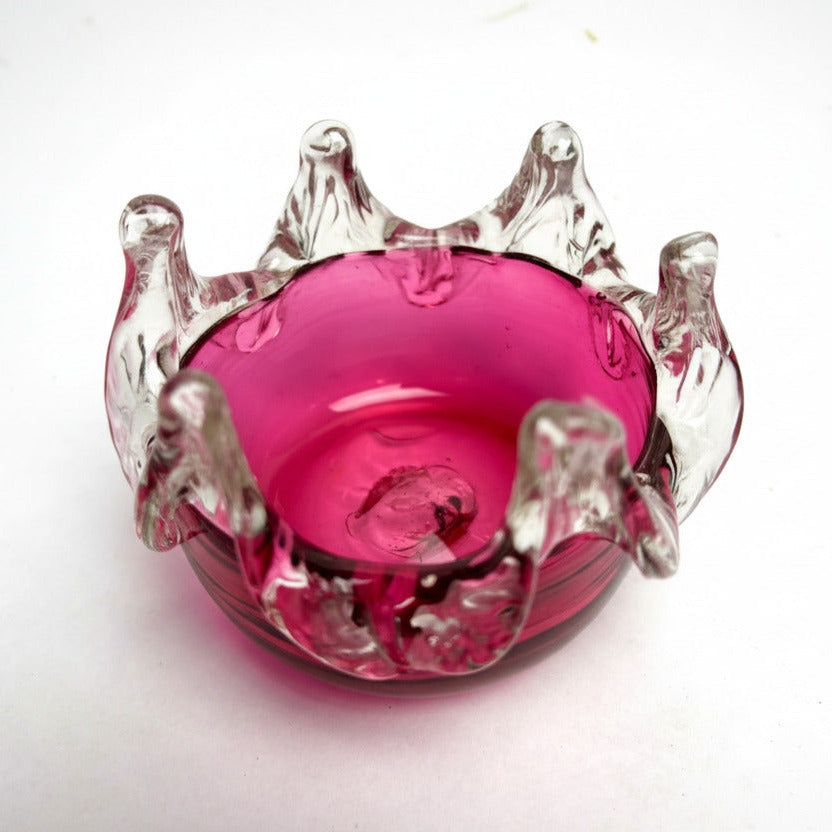 A small Cranberry Optical Ribbed Bowl with a pink glass body and clear glass ribbed design.