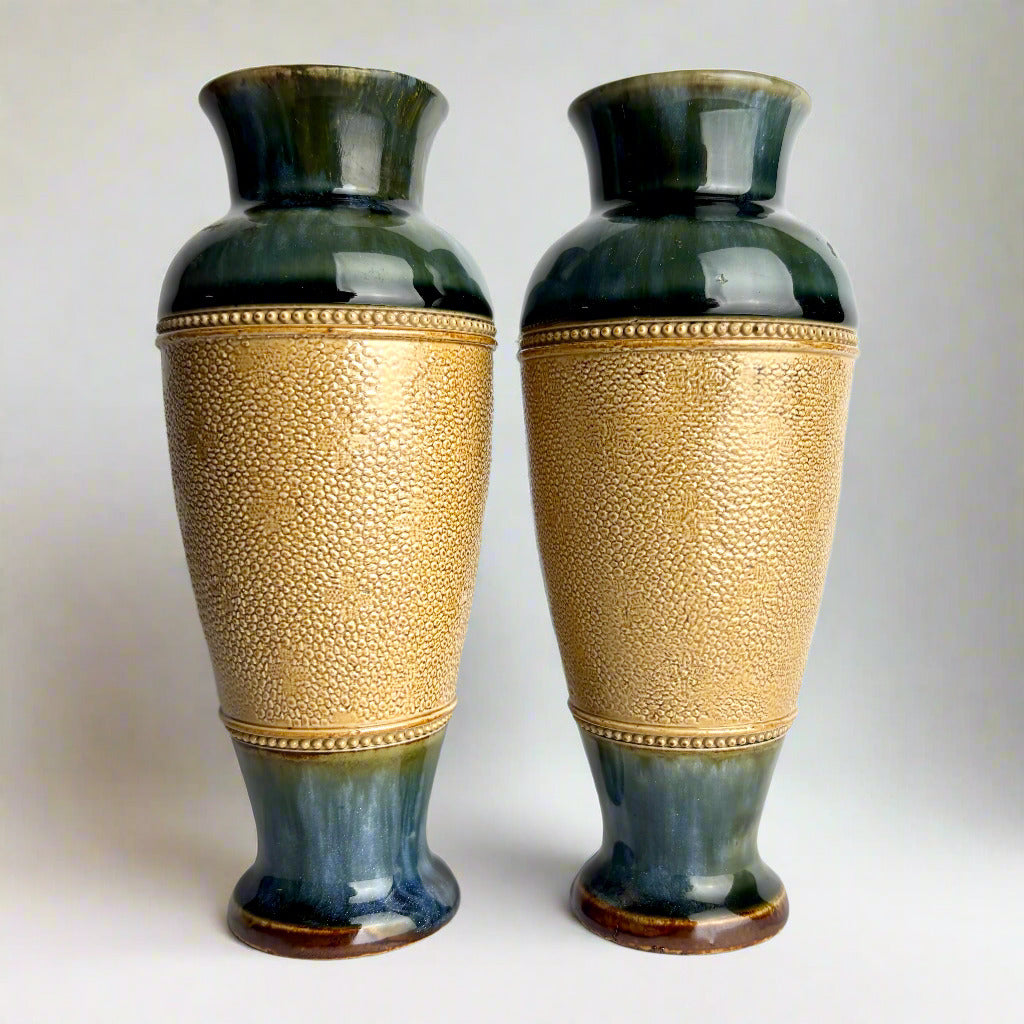 Two decorative vases with gold and black patterns on a white background