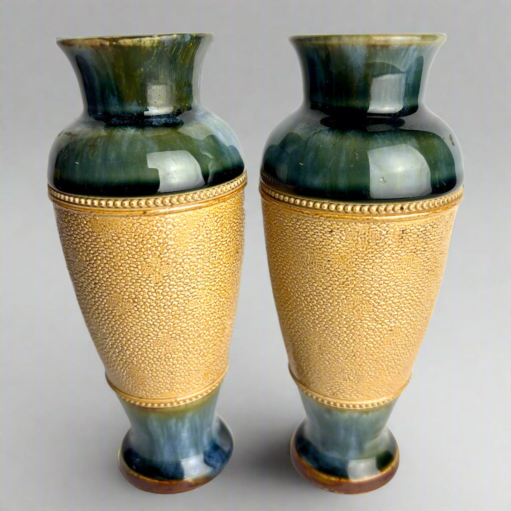 Two decorative vases with gold and green design on a gray background
