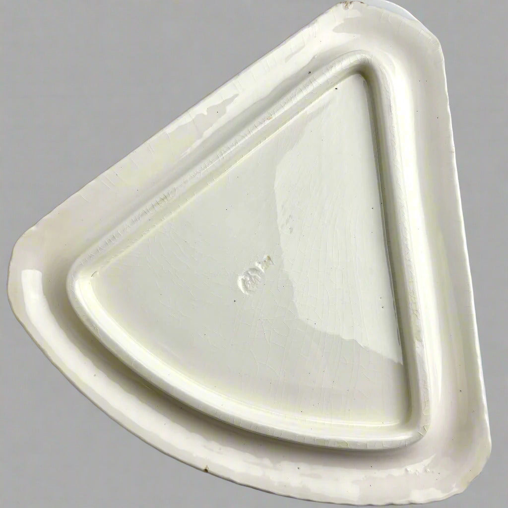 Triangular white ceramic dish on a gray background