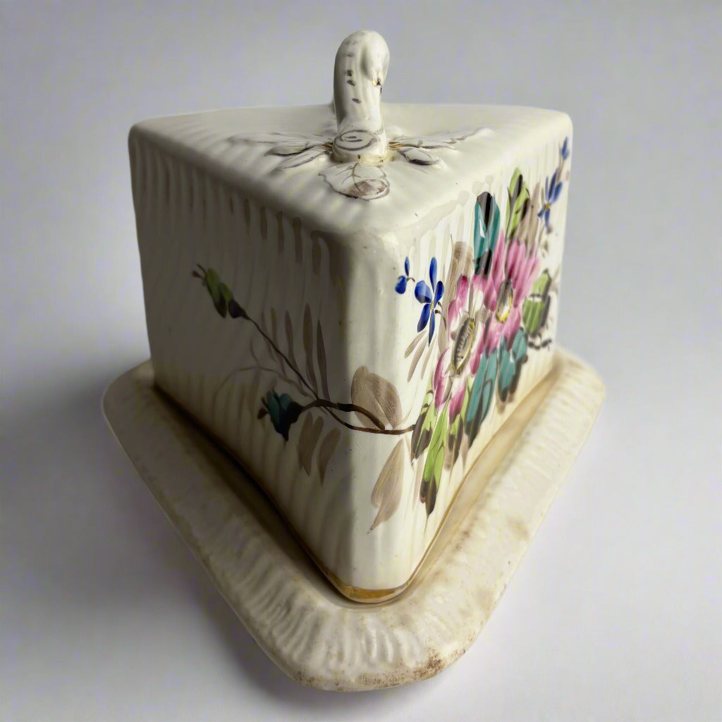 Ceramic butter dish with floral designs on a white background