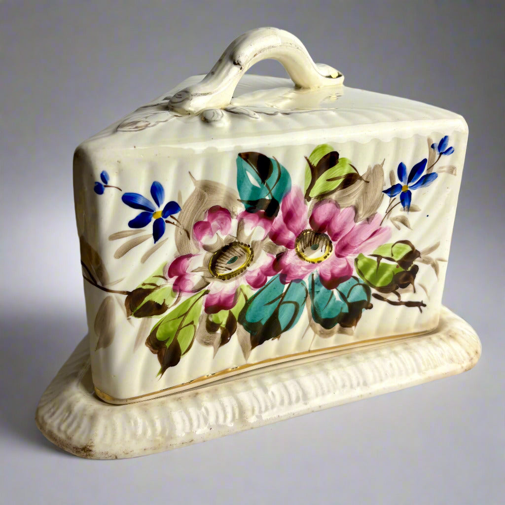 Ceramic butter dish with floral design on a plain background