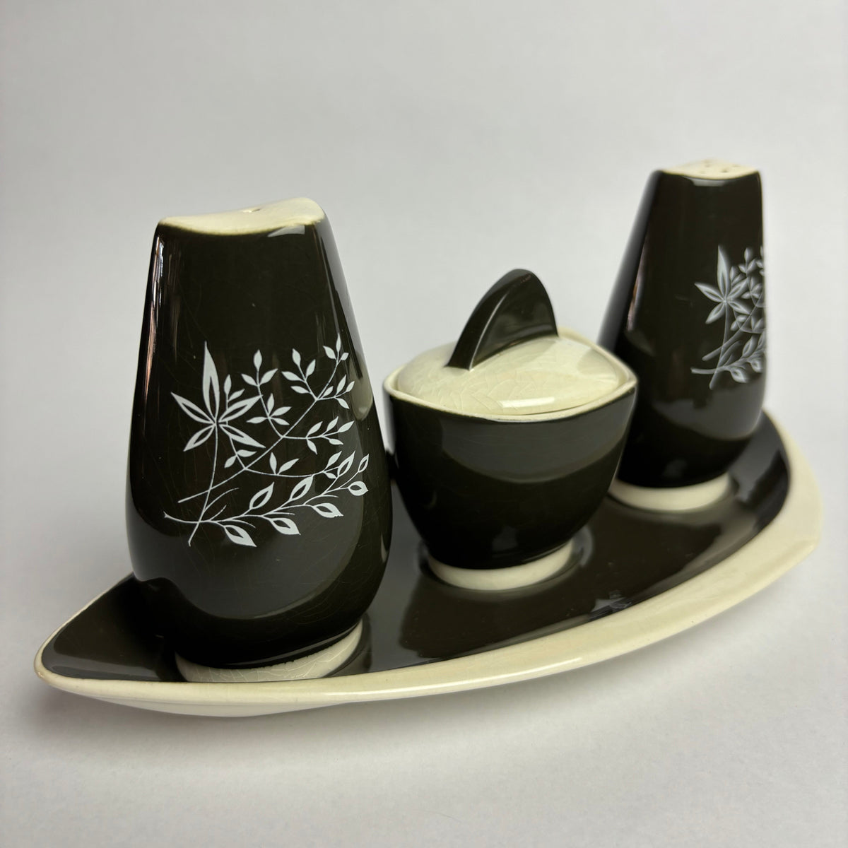 Black shoe trees with white floral patterns on a light gray background