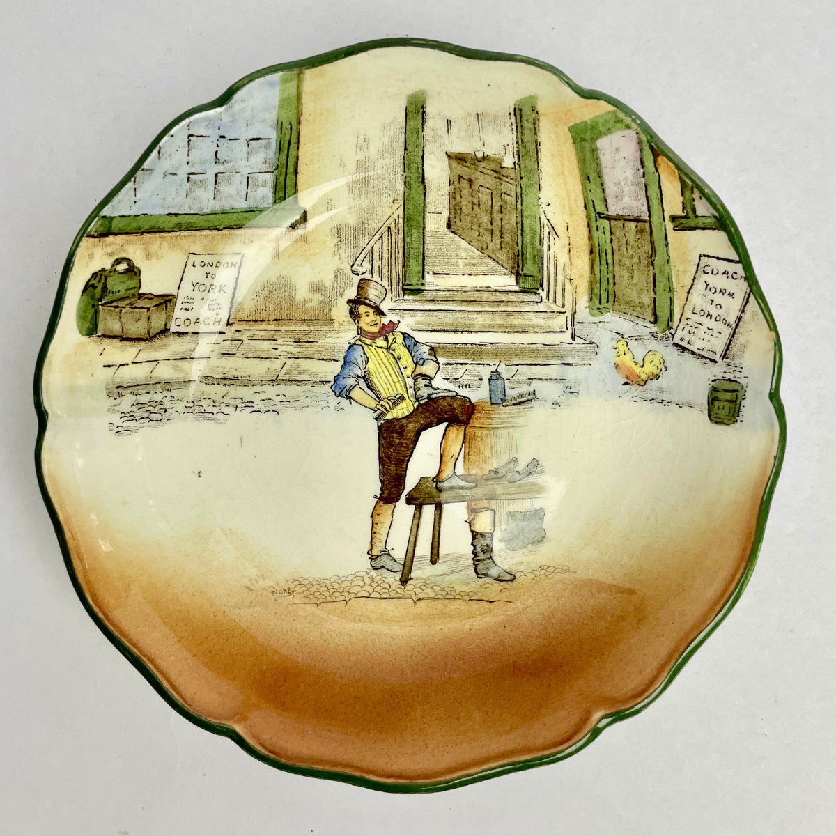 Decorative plate with a painted scene of a man sitting at a table, likely from a vintage or antique collection.